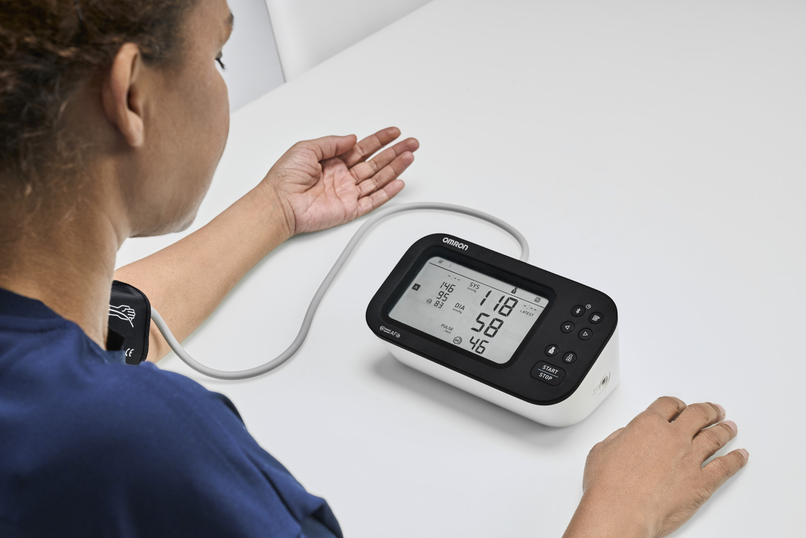 Woman taking blood pressure monitor at home