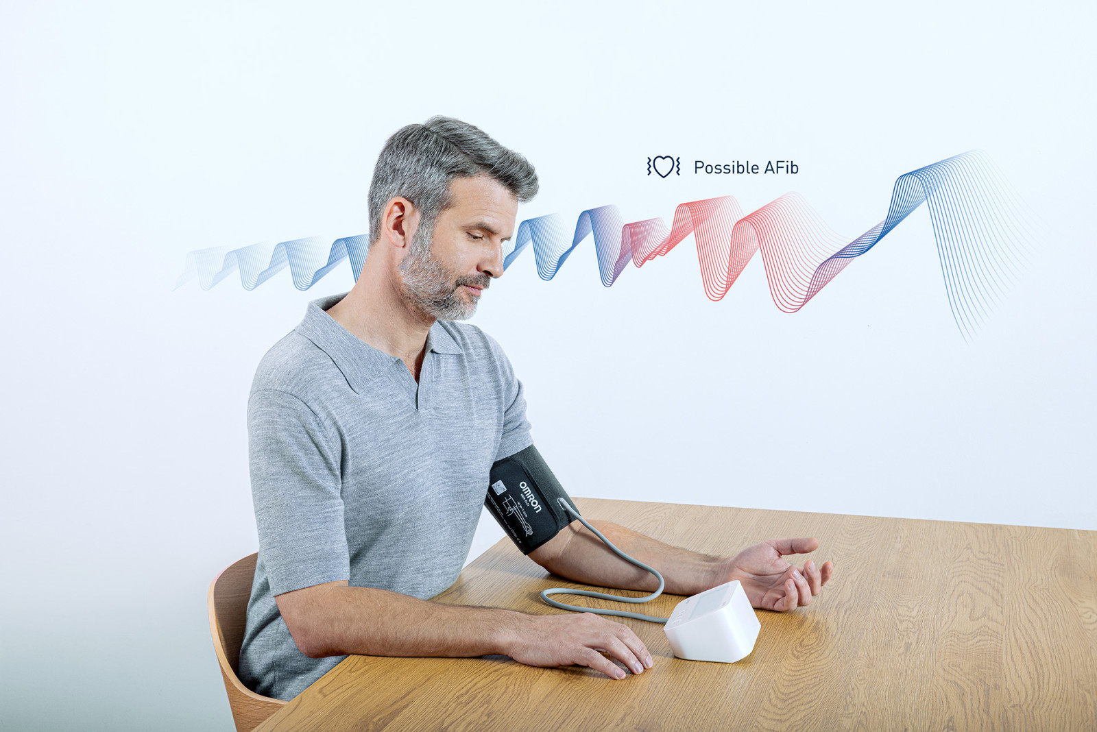 Man taking blood pressure monitor at table