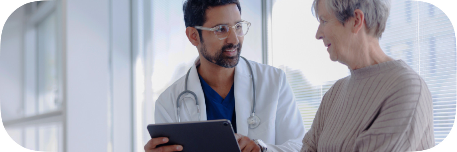 Doctor and Patient in Conversation Looking at Tablet