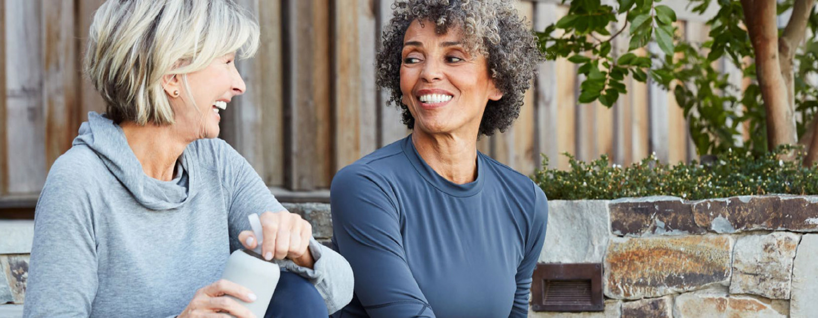 Two elderly women smiling at each other