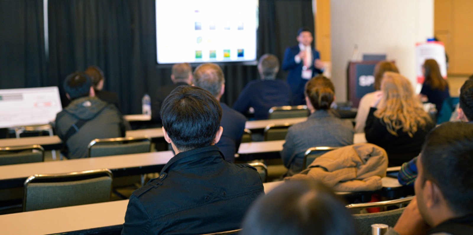 Speaker in auditorium filled with people