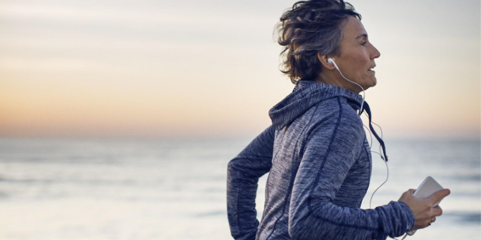 Older woman running with headphones