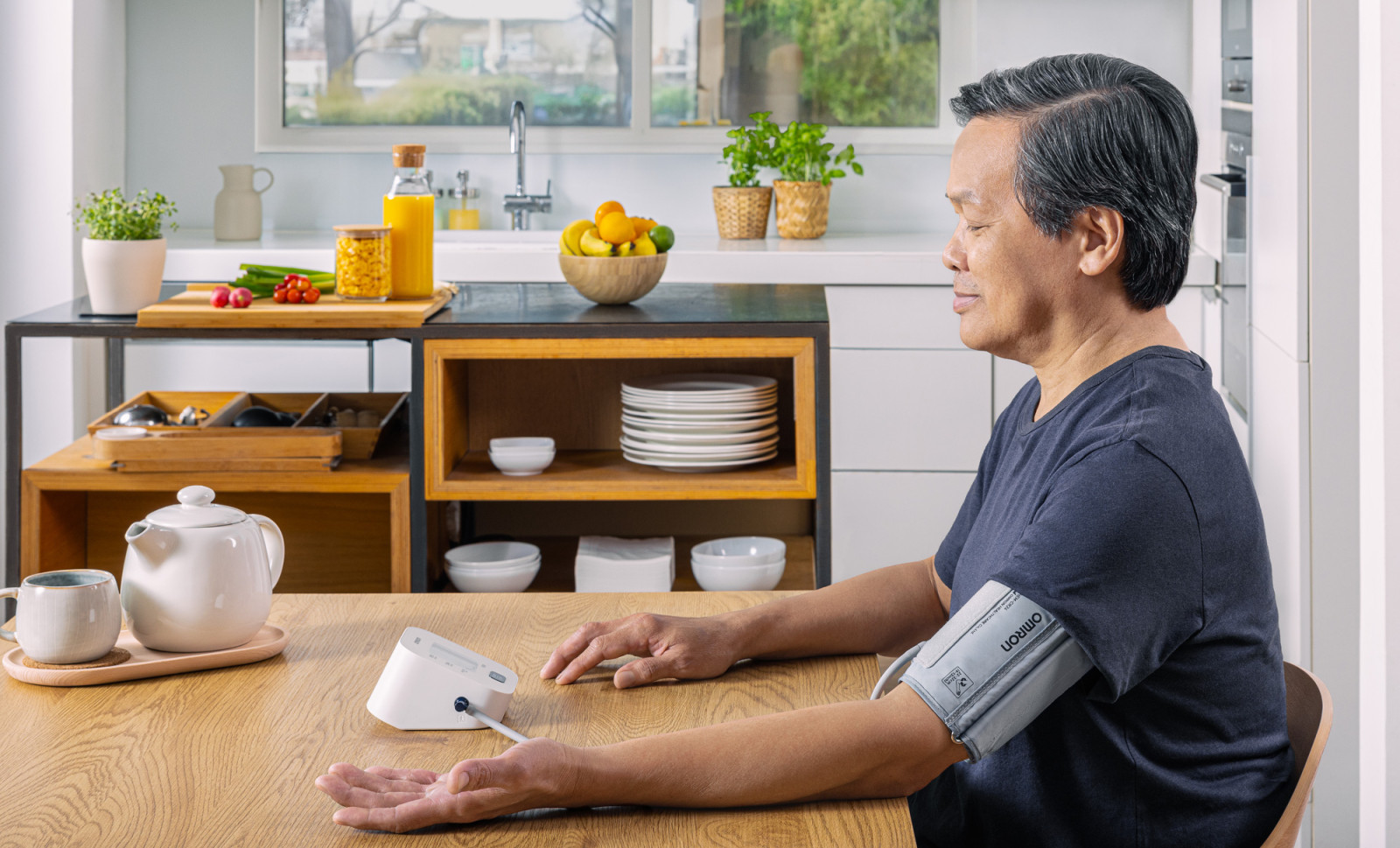 Man taking blood pressure monitor at home