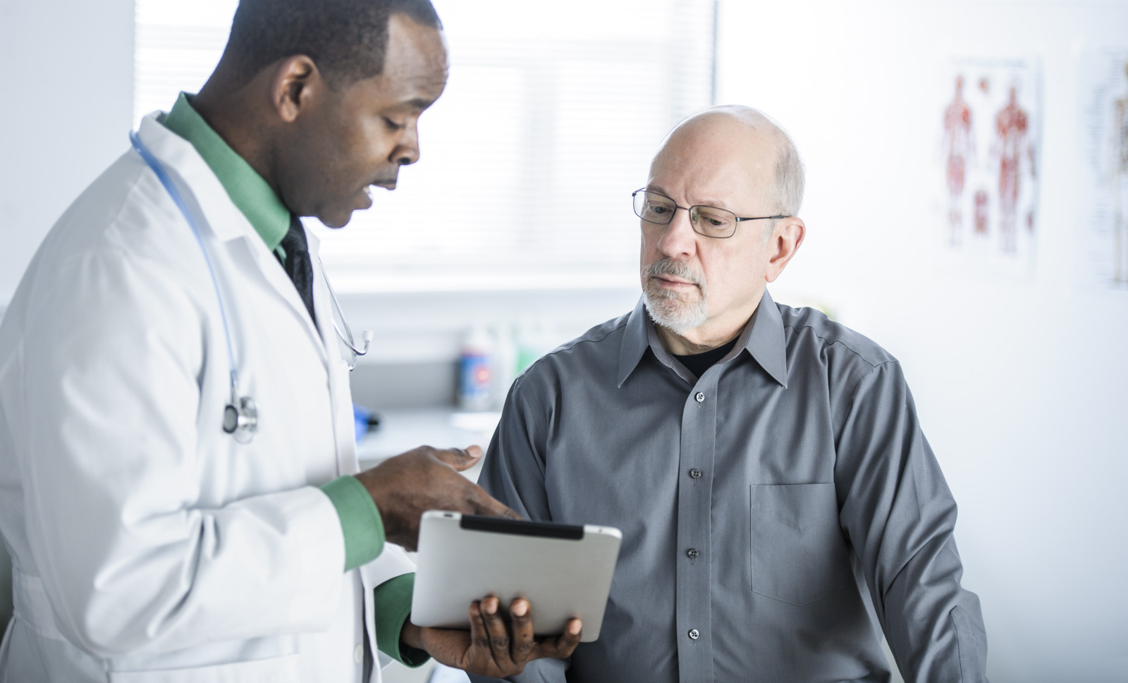 Doctor and Patient in Conversation Looking at Tablet