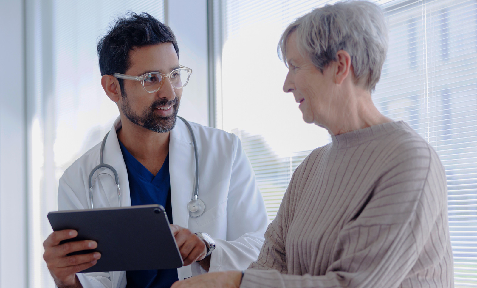 Doctor and Patient in Conversation Looking at Tablet