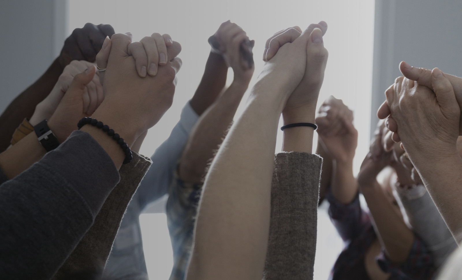 Group of people holding hands in air
