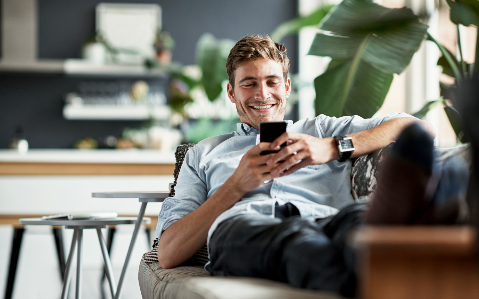 Man sitting on couch looking at phone