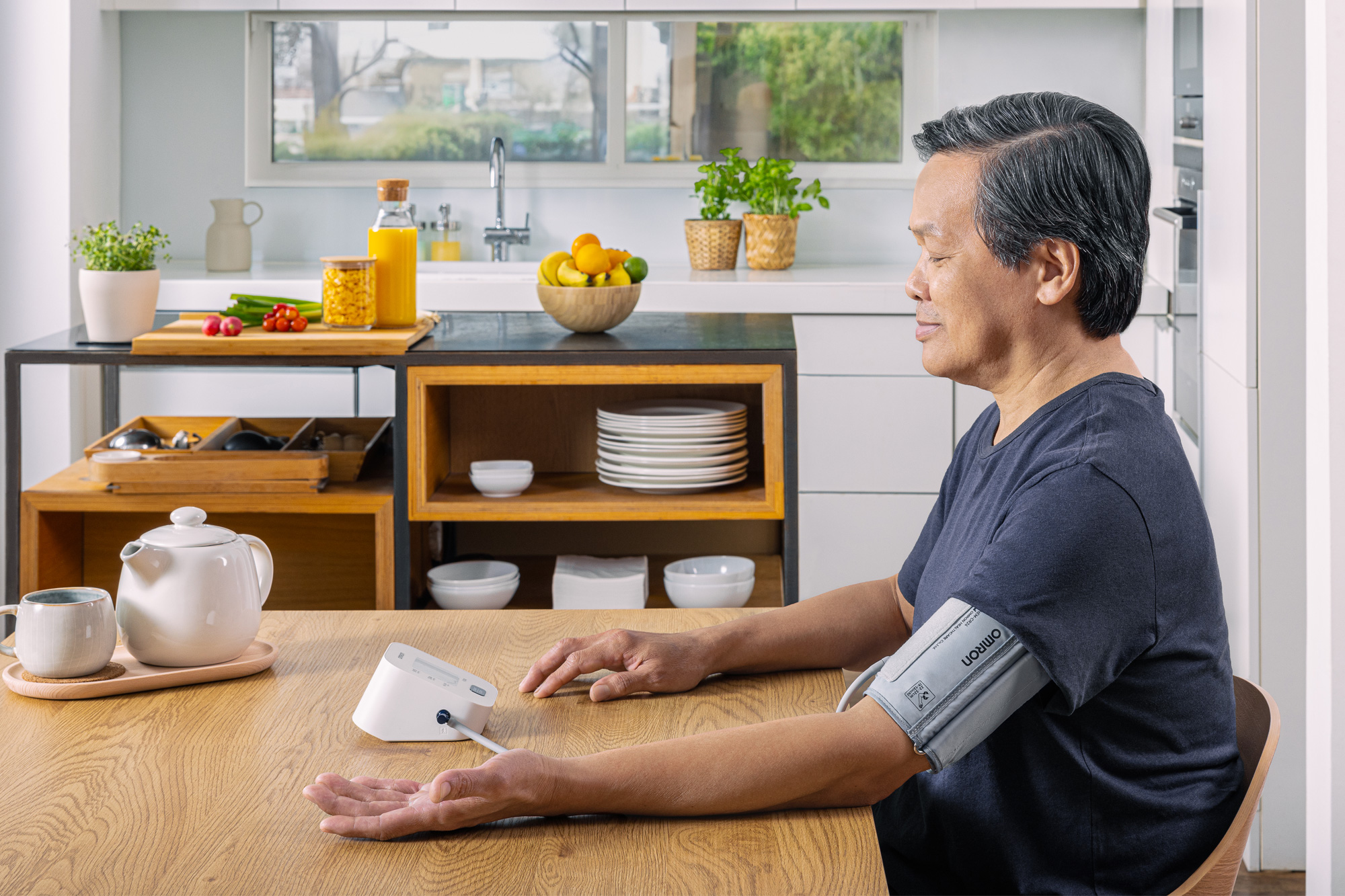 Man taking blood pressure monitor at home