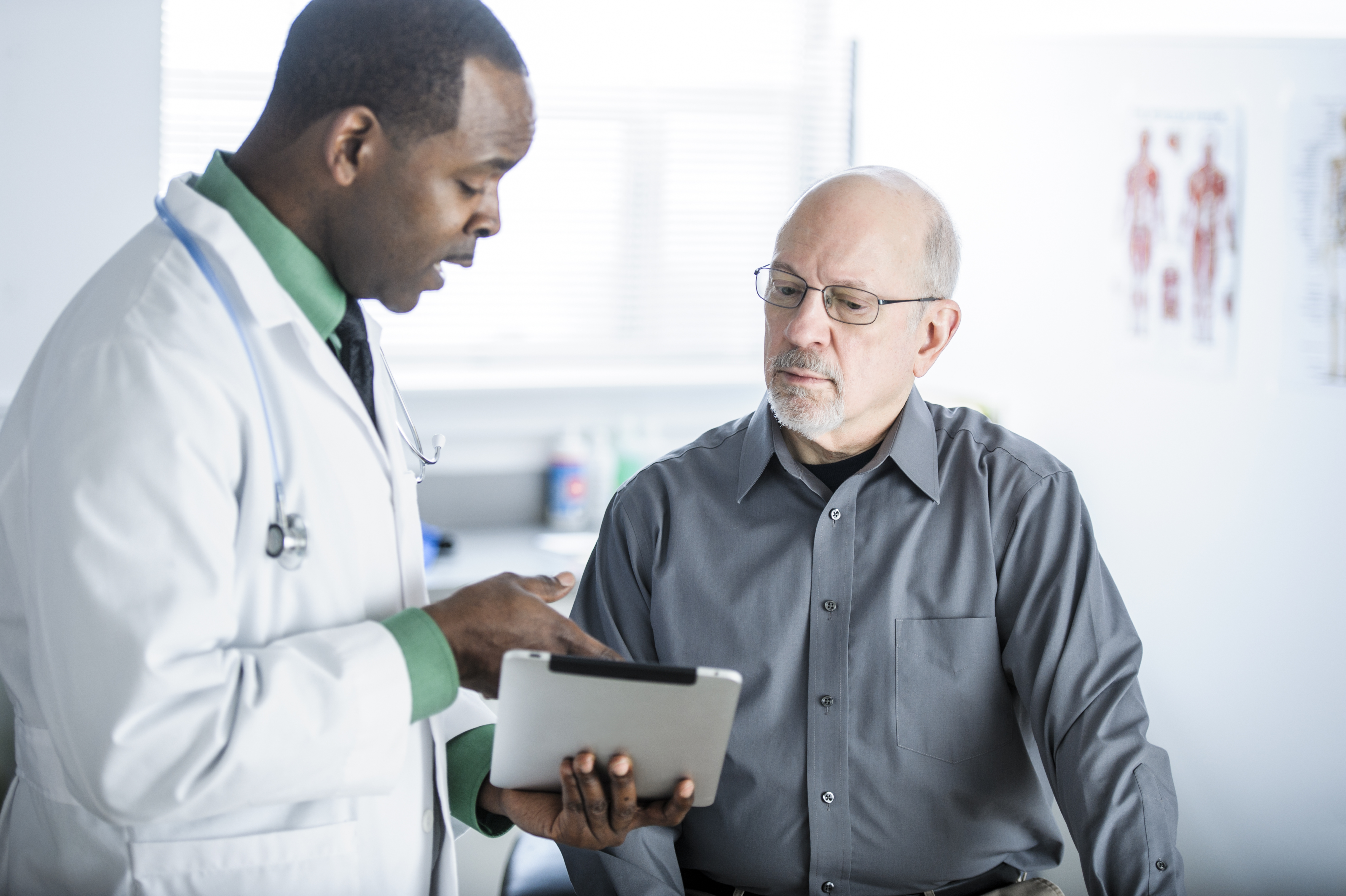 Doctor and Patient in Conversation Looking at Tablet