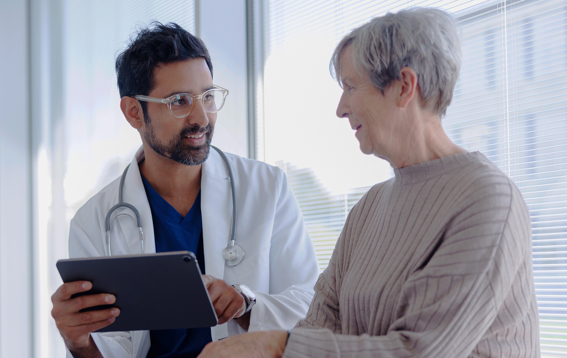 Doctor and Patient in Conversation Looking at Tablet